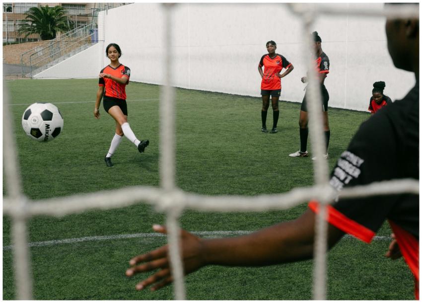A group of female soccer players practice on a gra