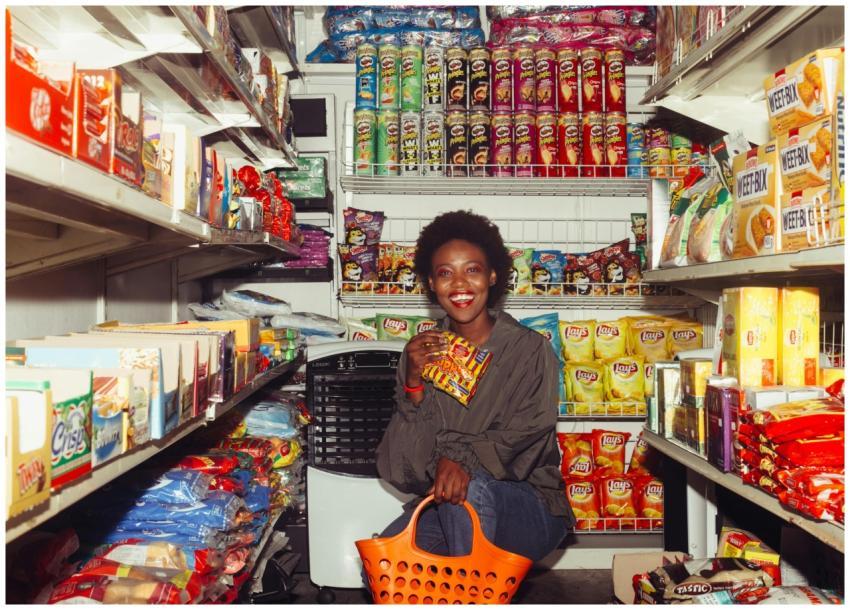 Happy black female in casual clothes with shopping