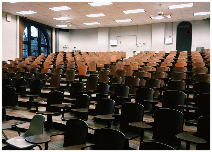 Empty university lecture hall with wooden chairs a