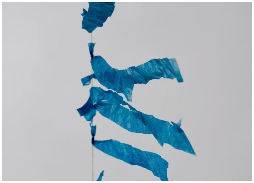 Close-up of blue streamers against a grey sky, cap