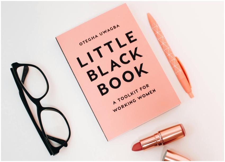 Pink flat lay featuring a book, glasses, pen, and