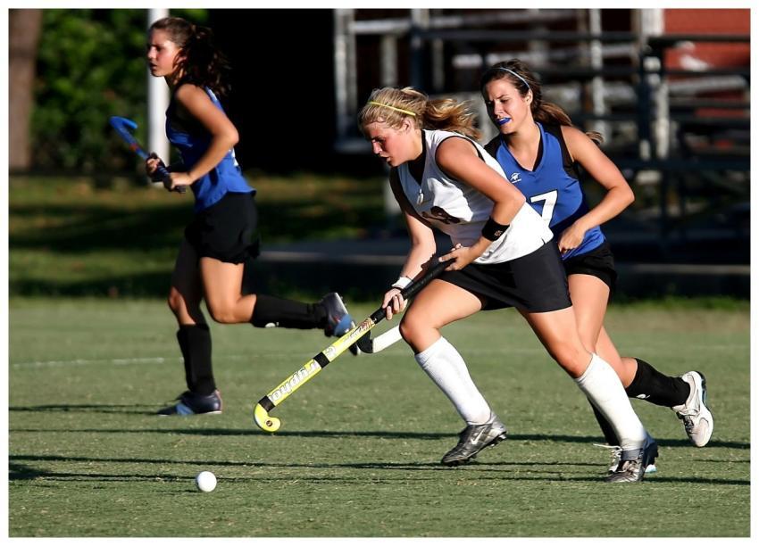 Energetic field hockey game with women players com