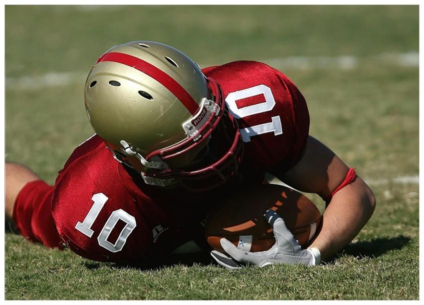 American football player wearing red uniform holdi