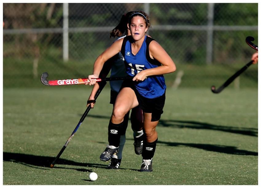 Dynamic action shot of a female field hockey playe