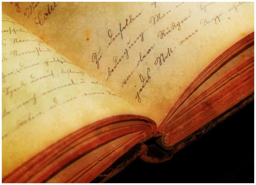 Close-up of an antique book showing handwritten te