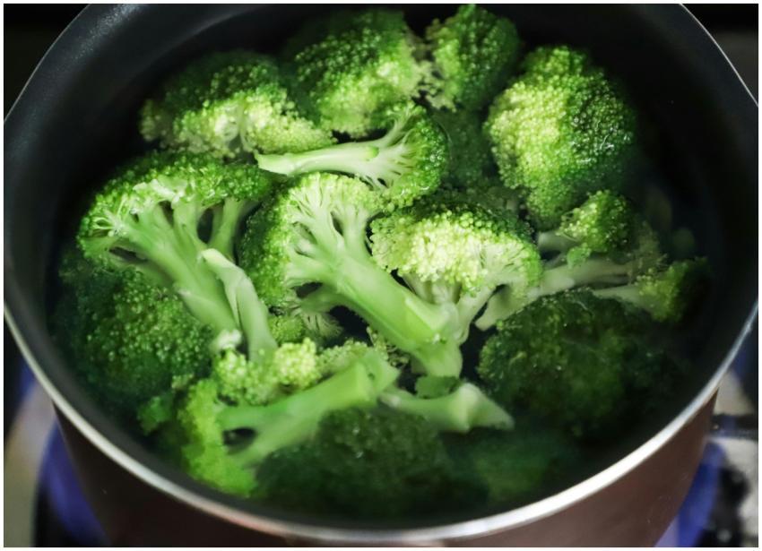 Bright green broccoli florets boiling in a pot for
