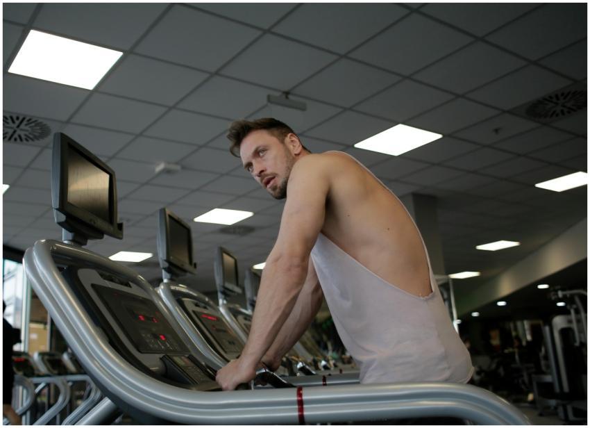 A focused man exercising on a treadmill in a moder