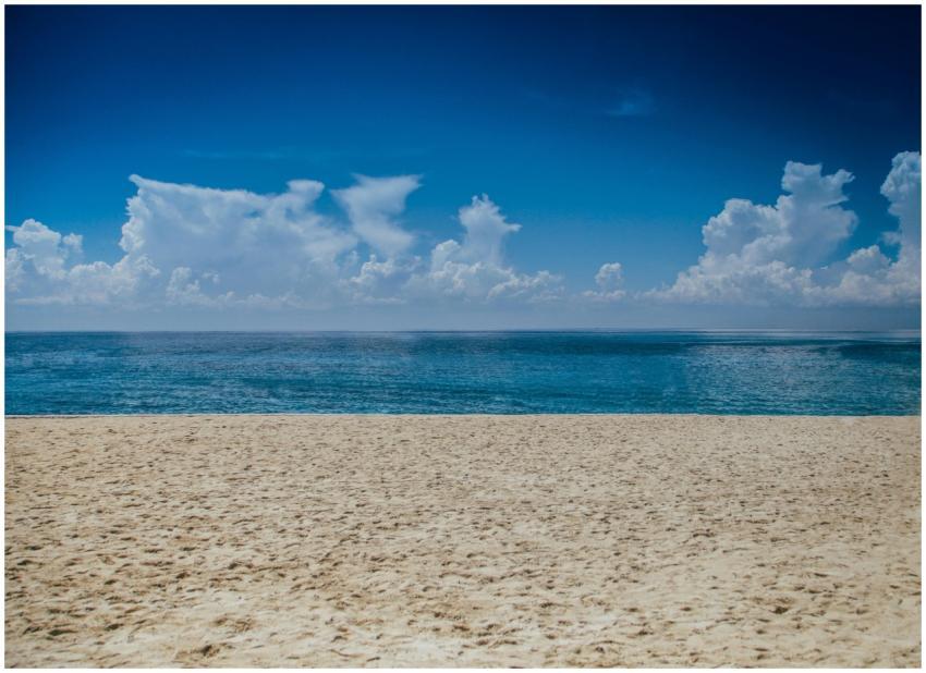 A tranquil beach scene with clear skies and gentle