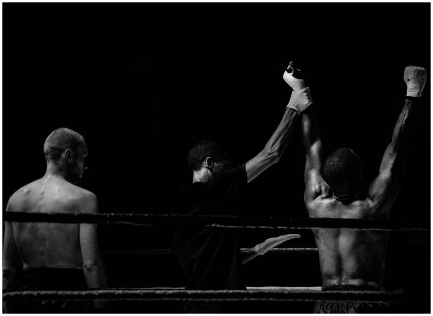 Black and white image capturing a victorious boxin