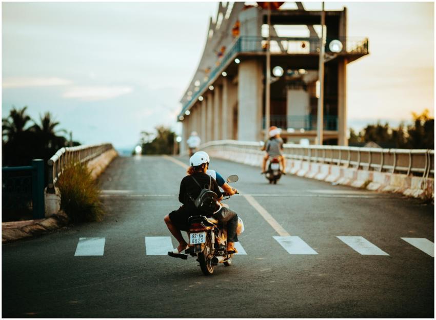 Motorcyclists Crossing Bridge Sunset