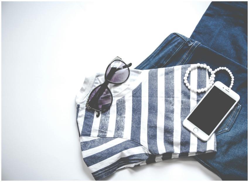 Flat lay image featuring sunglasses, striped top,