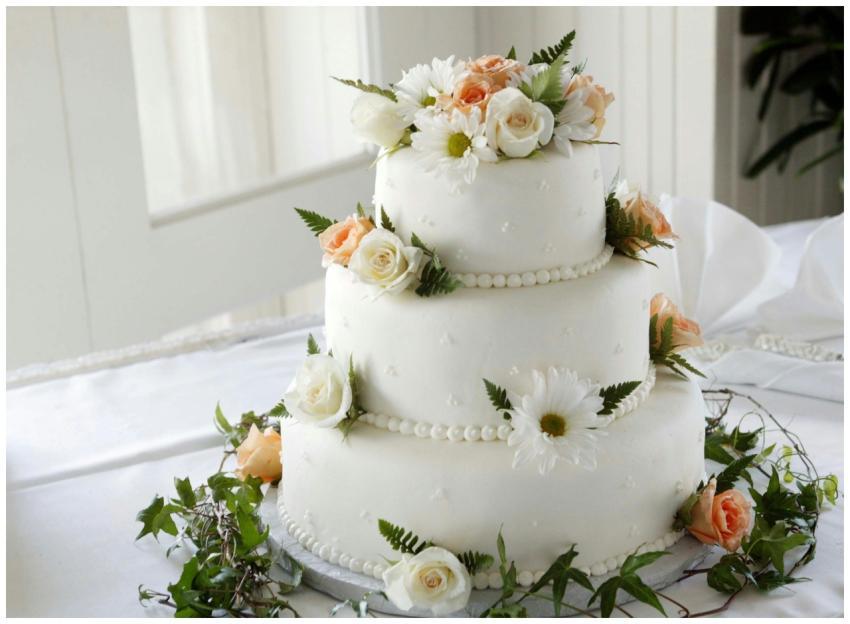 Elegant white wedding cake adorned with fresh rose
