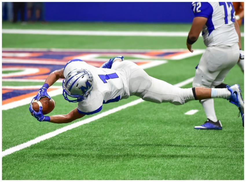 Football player making an incredible diving catch