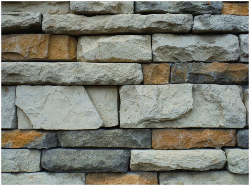 Close-up of a textured stone wall with a variety o