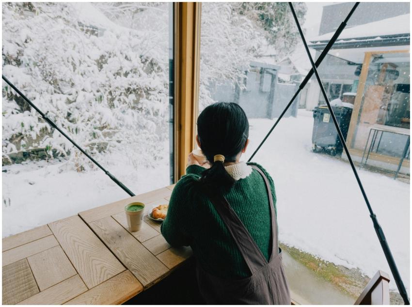 Woman enjoying a warm drink inside a café overlook