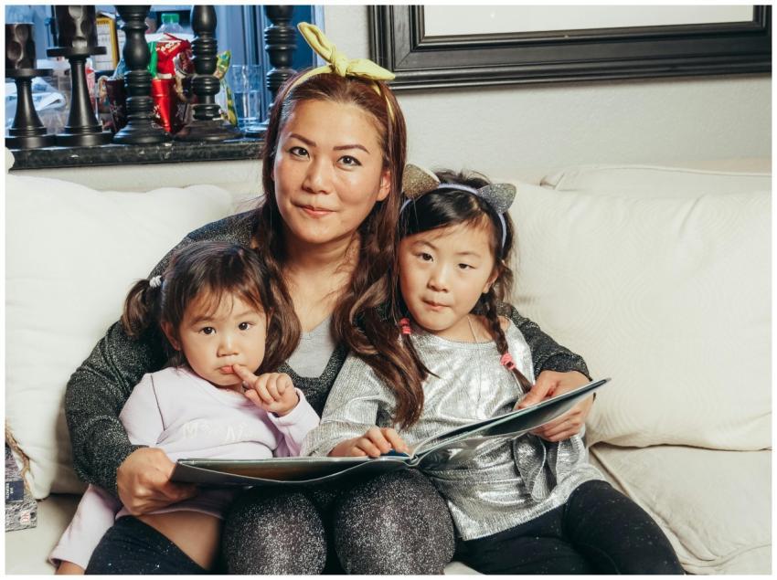 Cozy family moment with a mother reading a book wi