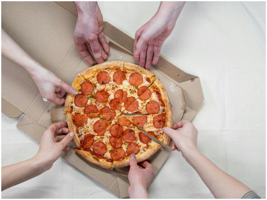 Group of friends sharing a delicious pepperoni piz