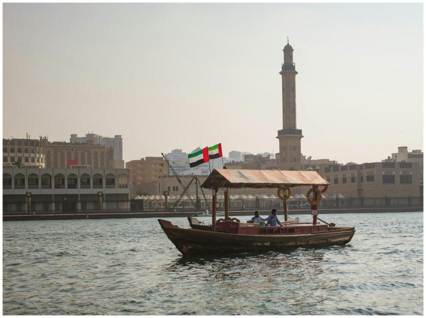 A traditional abra boat sails on Dubai Creek with