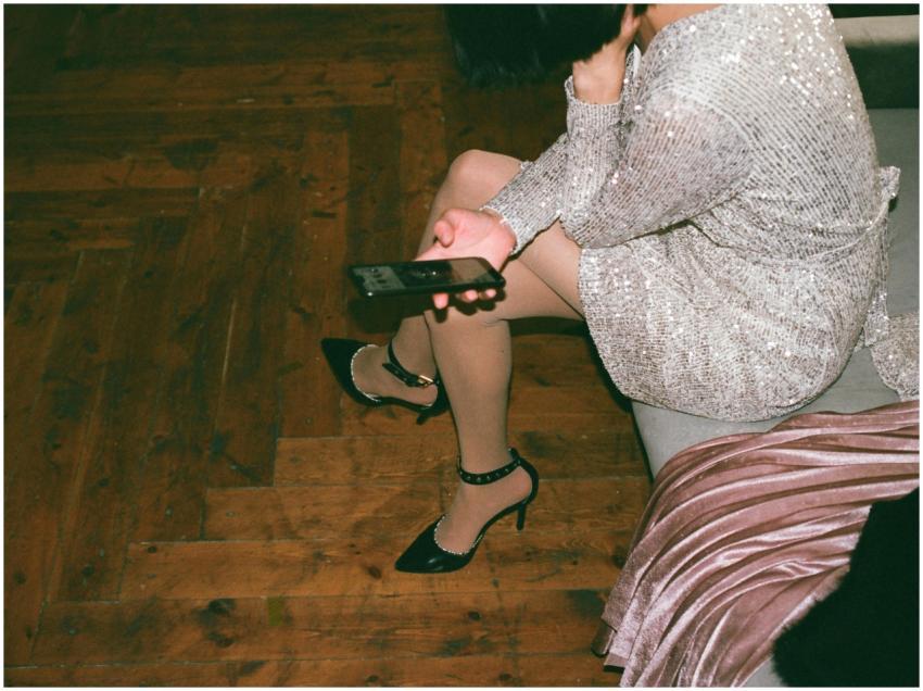 A woman in a silver sequin dress sitting indoors,