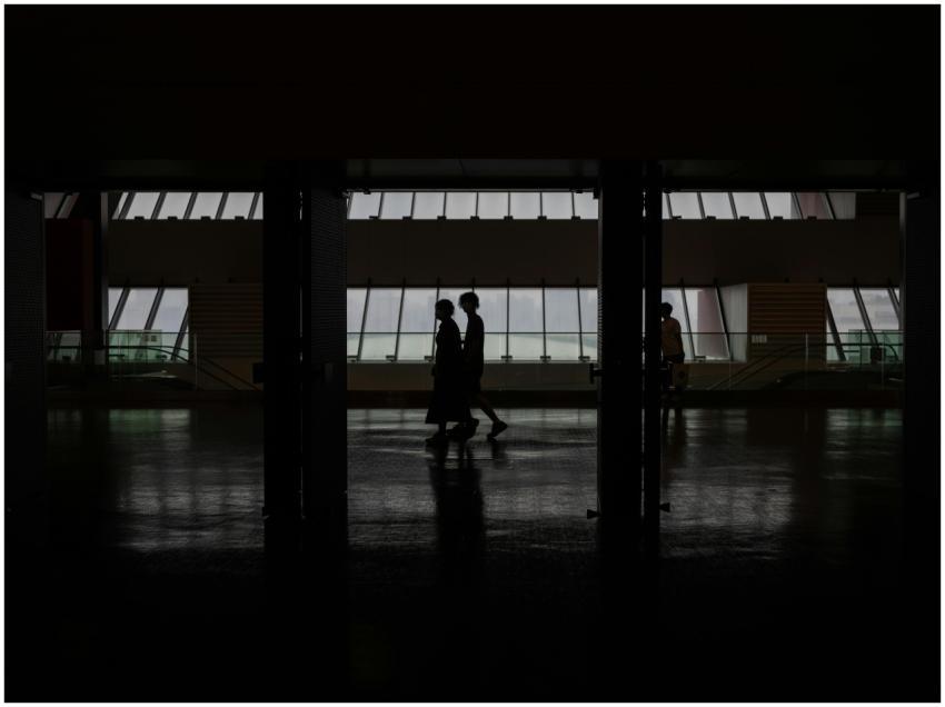 Silhouette of people walking through a modern hall