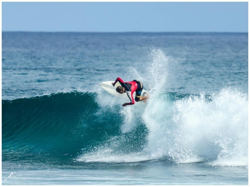 A surfer performs a thrilling maneuver on a wave i