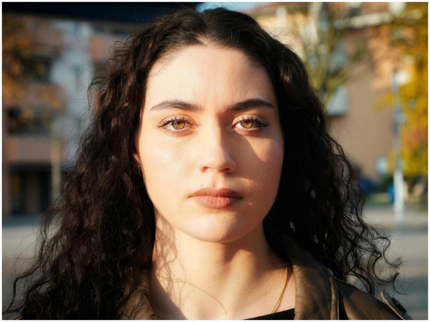 Close-up portrait of a young woman outdoors, with