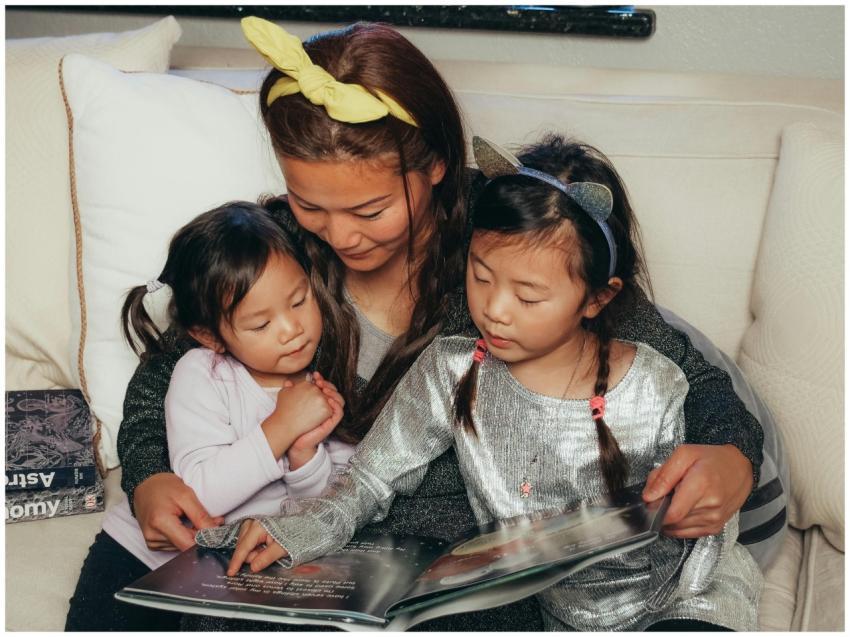 A cozy moment of mother and daughters reading toge