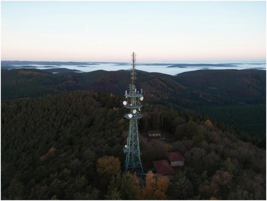 Aerial view of a radio tower amidst autumn forests