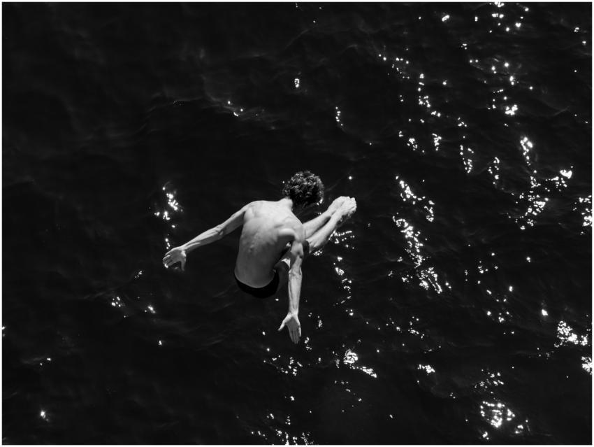 A fearless diver leaps into the ocean, capturing a