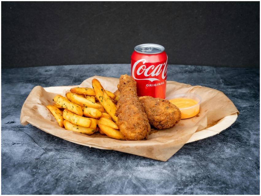 Close-up of crispy fried chicken, fries, and a can