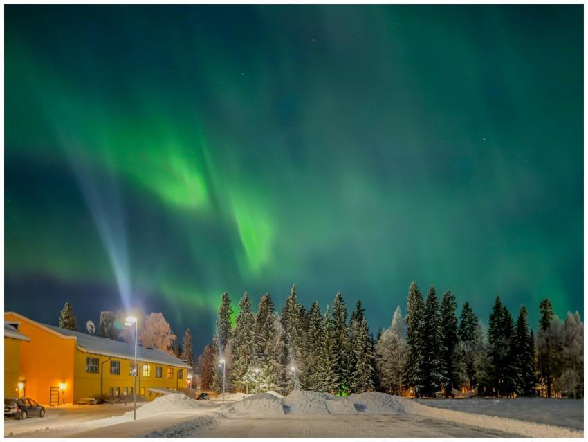 Aurora borealis shines over a snowy landscape in B