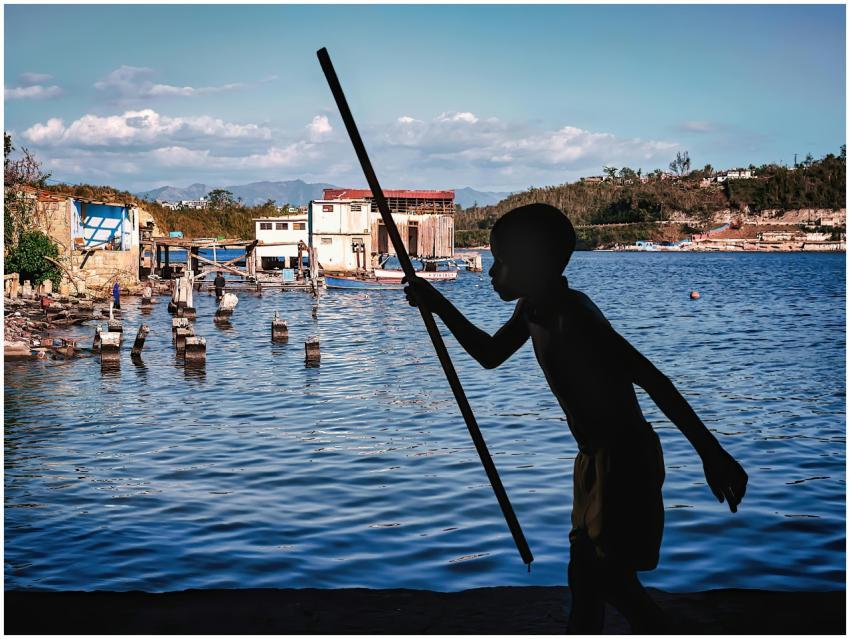 A striking silhouette of a boy holding a stick by