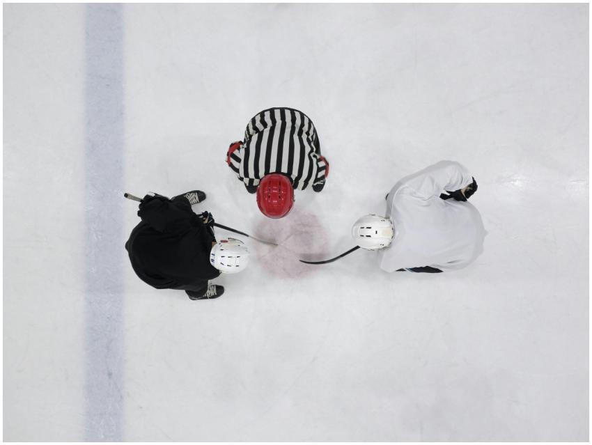 Top view of an ice hockey faceoff with players and