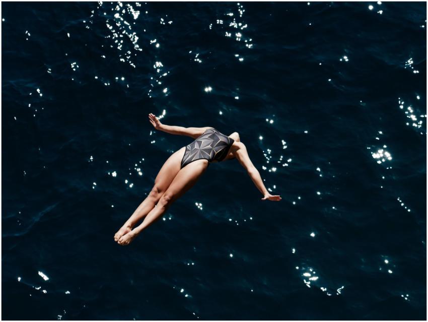 A woman in swimwear fearlessly dives into the deep