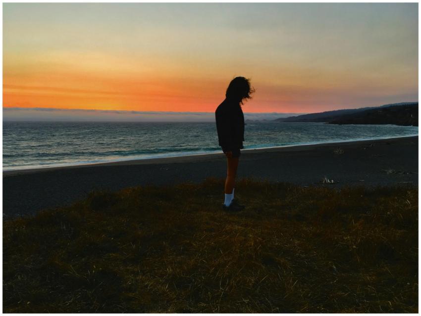 Silhouette of a woman standing by the ocean during