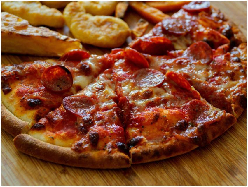 Delicious pepperoni pizza slices on a wooden board
