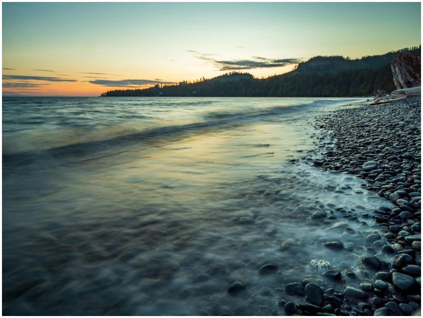 Tranquil sunset over a pebbled shoreline in Britis