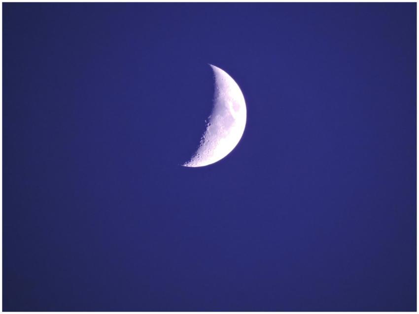 A clear, luminous crescent moon photographed in a