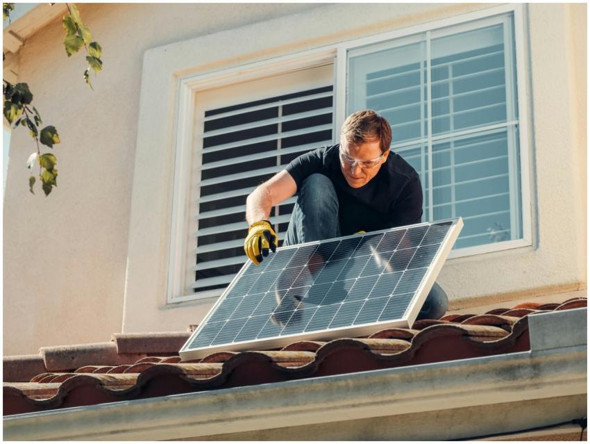 Solar technician installing a photovoltaic panel o