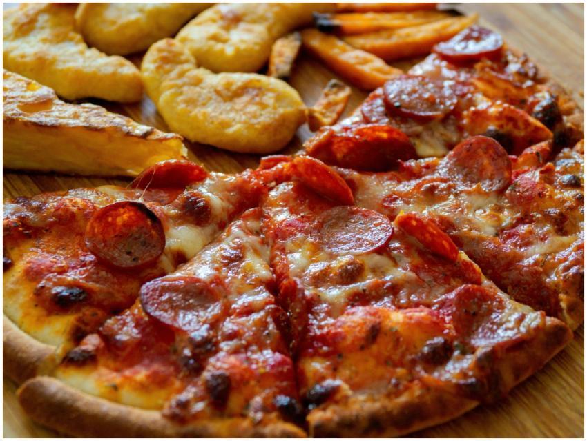 A tempting close-up of pepperoni pizza, chips, and