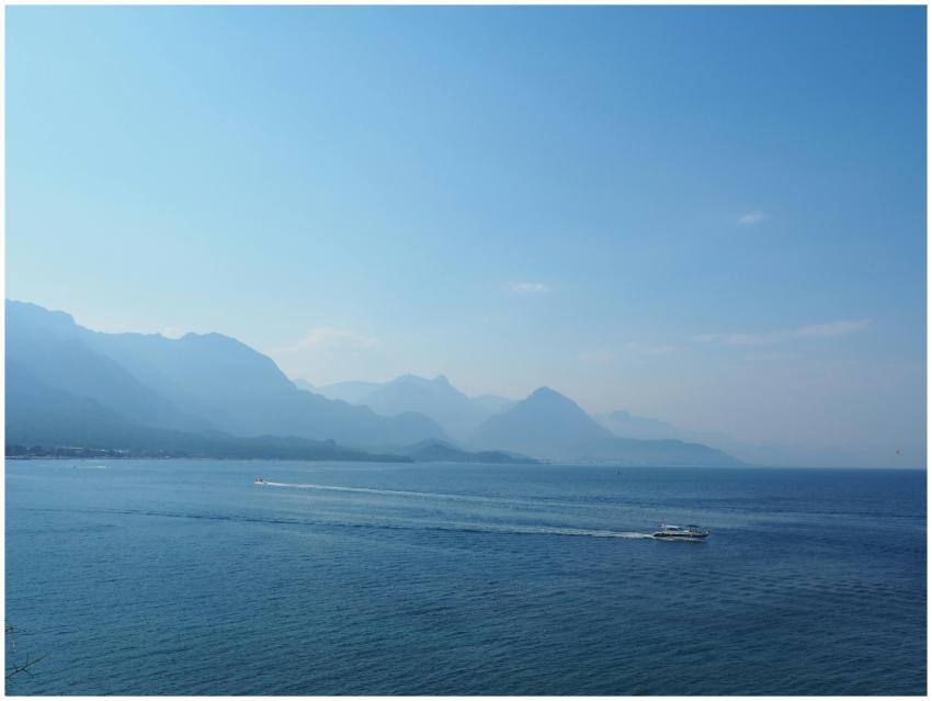 Tranquil seascape featuring a distant boat and mou