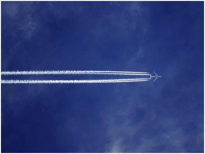 A jet airplane leaves contrails in a clear blue sk
