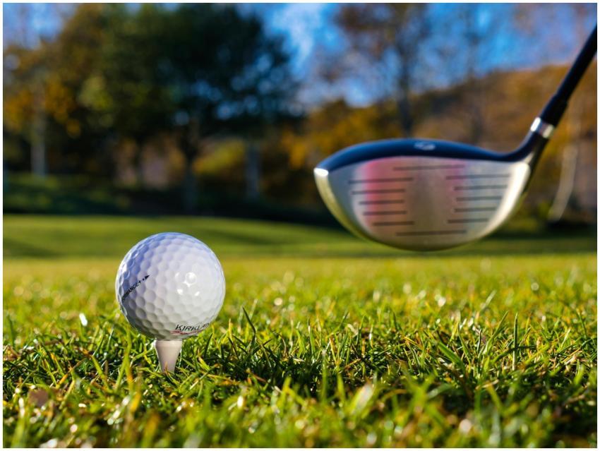 Close-up of a golf ball on a tee with a golf club