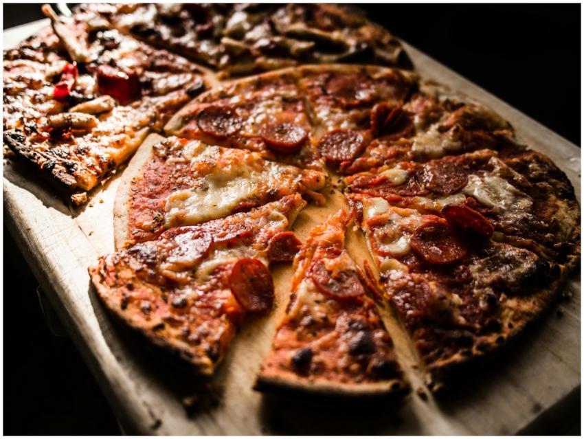 Delicious crispy pepperoni pizza slices on a woode