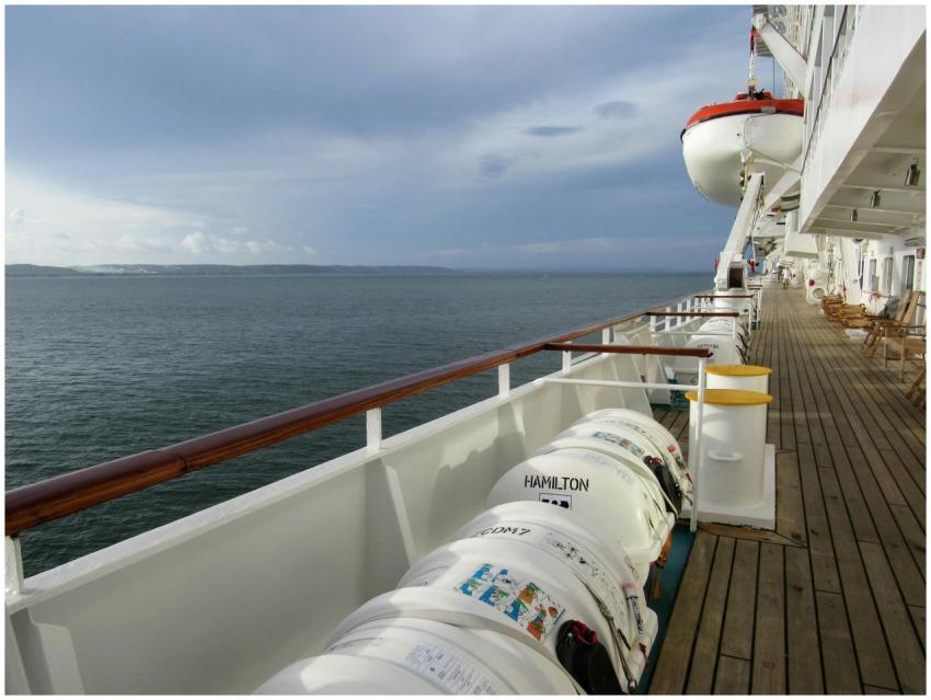 Empty cruise ship deck with lifeboats overlooking