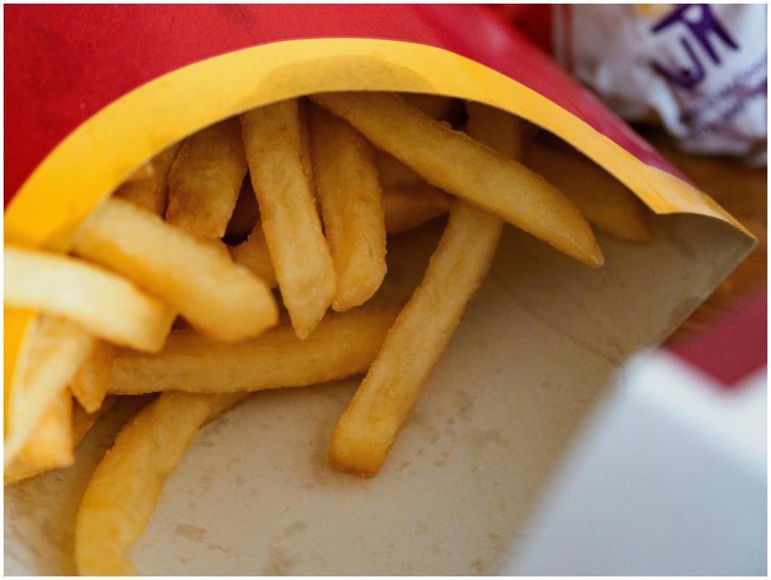 Close-up of crispy golden french fries in a takeaw