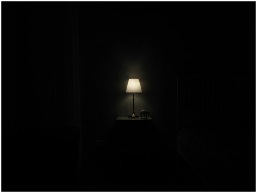 Illuminated lamp on nightstand casting a warm glow