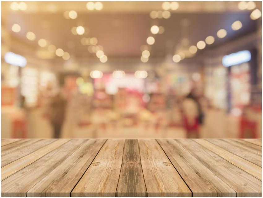 Empty wooden table with blurred shopping mall back