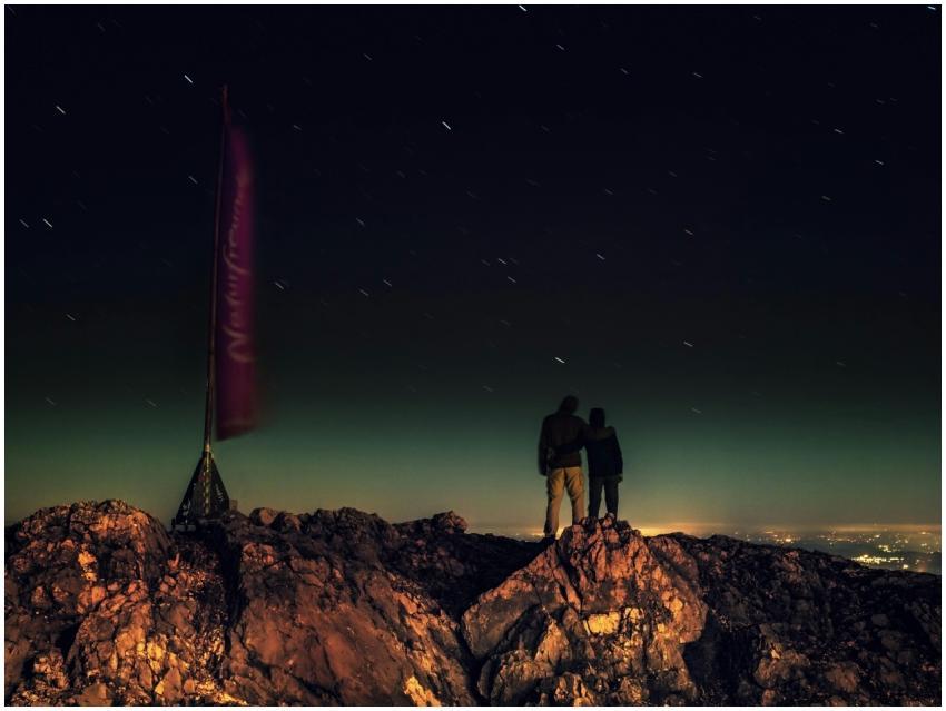 A couple gazing at the stars atop a mountain in Au