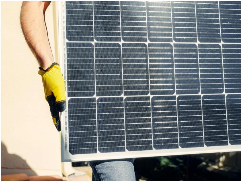 Close-up of a person installing a solar panel outd